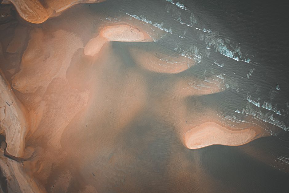 Stunning aerial view of natural sand formations along the coast with gentle waves.